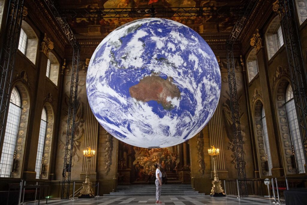 A staff member looks at Luke Jerram's artwork Gaia, a replica of planet Earth created using detailed NASA imagery of the Earth's surface, as it goes on display in the Painted Hall of the Old Royal Naval College, Greenwich, London, as part of the 2020 Greenwich+Docklands International Festival. (Photo by Victoria Jones/PA Images via Getty Images)