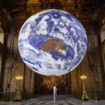 A staff member looks at Luke Jerram's artwork Gaia, a replica of planet Earth created using detailed NASA imagery of the Earth's surface, as it goes on display in the Painted Hall of the Old Royal Naval College, Greenwich, London, as part of the 2020 Greenwich+Docklands International Festival. (Photo by Victoria Jones/PA Images via Getty Images)